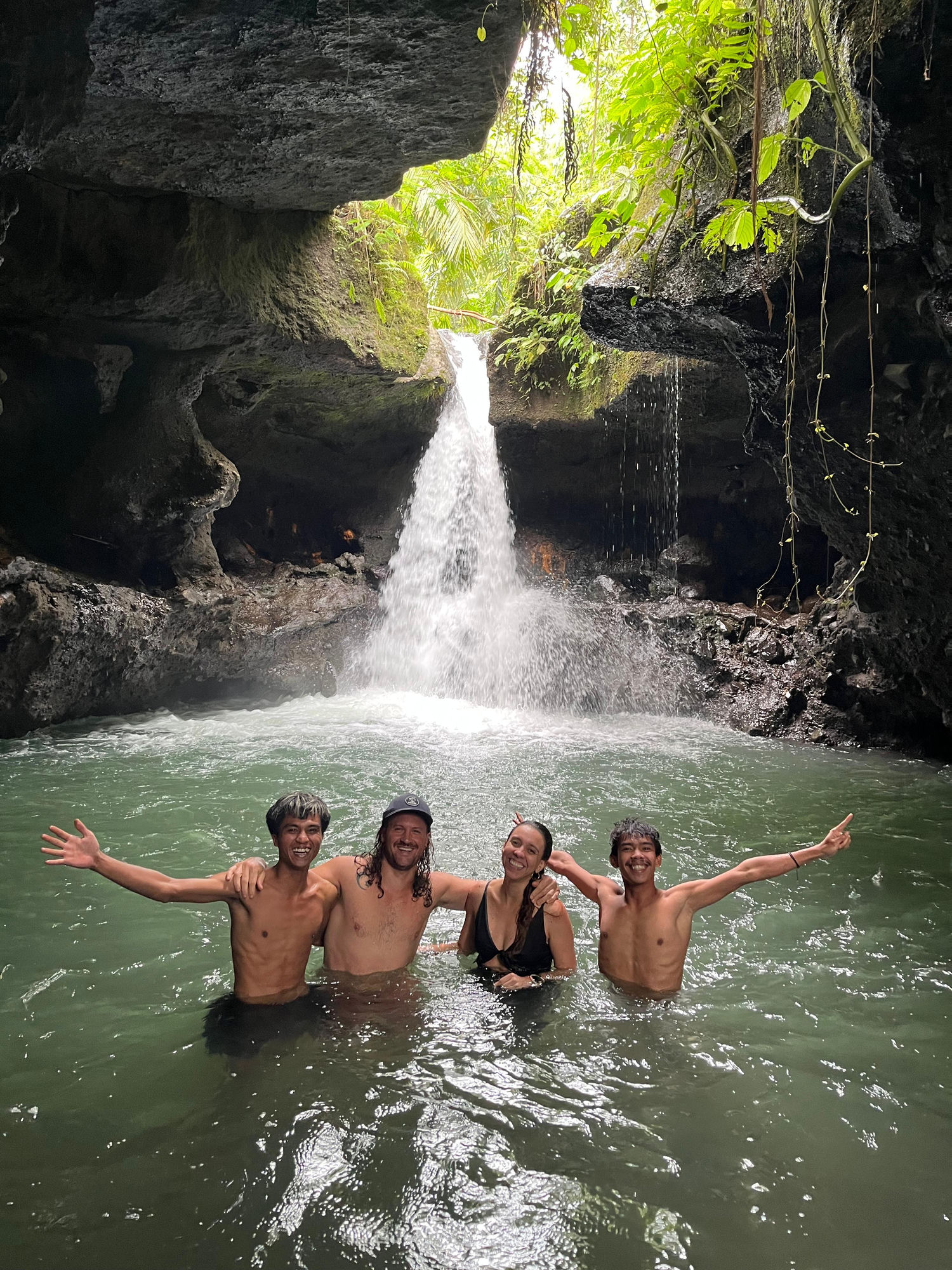 Guide and guests at a hidden cave waterfall, Lombok